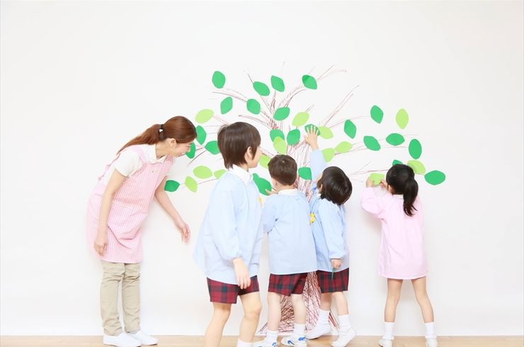 教室の壁面に工作物を作成する園児たち
