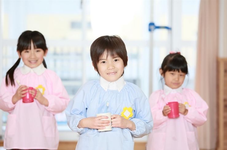 給食のお茶の配給を待つ園児